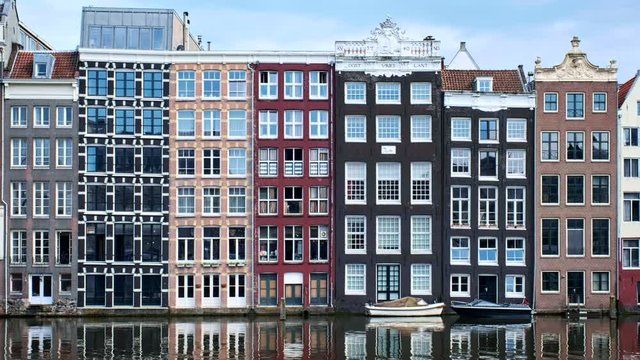 houses and boat on Amsterdam canal Damrak with reflection. Ams