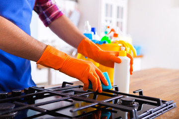 Man makes cleaning the kitchen. Young man washes an oven. Cleaning concept.