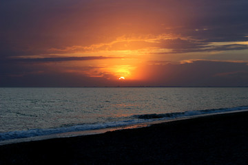 Fototapeta premium The sea and the beach, a red sunset over the sea, romance. Can be used as a background