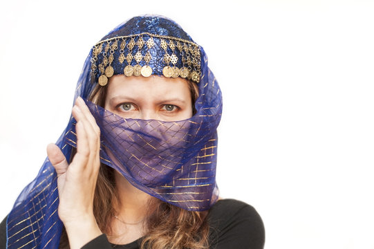 Portrait of a beautiful woman on white background in blue paranja with golden embellishments. Isolated