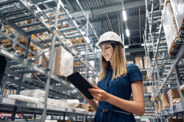 Beautiful young woman worker of furniture store in shopping center. Girl looking for goods with a...
