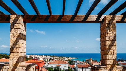 Frame of coastline of Costa Dorada in Miracle Beach. Sea, beach, palms and tiled roofs of houses at Tarragona, Catalonia, Spain