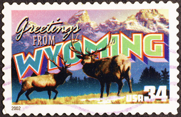 Greetings from Wyoming postcard on postage stamp