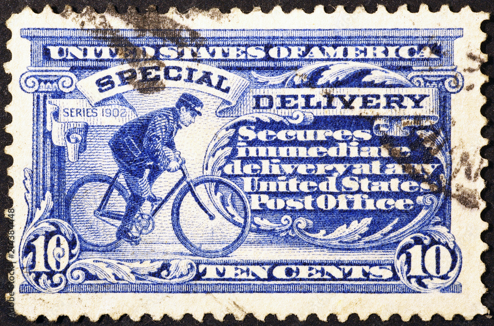 Wall mural postman cycling on very old american postage stamp