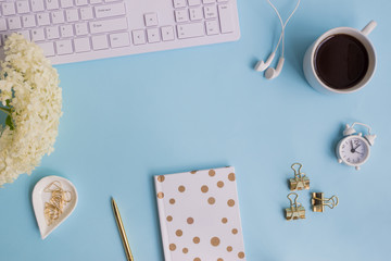 Blogger or freelancer workspace with notebook and white flower hydrangea