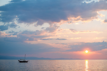 Naklejka na ściany i meble Fishing boat on the sunrise in the sea
