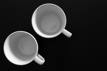 Empty white cups on black wooden table