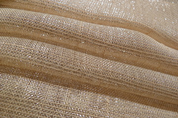 shiny fabric close-up of the folds on the material structure of the fibers of the recolonies of the threads background for the decor of the lurex brocade organza natural curtains upholstery for furnit