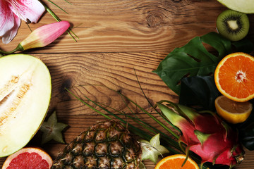 Assortment of tropical fruits with leaves of palm trees and exotic plants