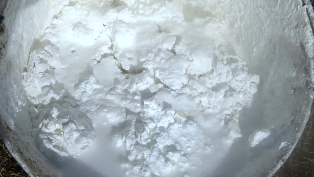 Chemical reaction. Lime slaking in a stainless steel bucket. It is used for whitewashing trees.