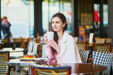 Woman drinking coffee in outdoor cafe or restaurant, Paris, France