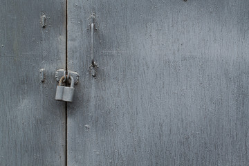 Fototapeta na wymiar old metallic gray door closed on a padlock