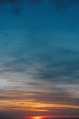 Obraz premium Sunset. Amazing beautiful sunset or sunrise on sky with clouds in yellow, pink and blue colors. Dawn or dusk. Nature wallpaper.