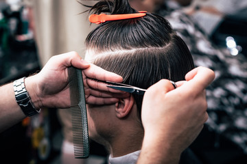 A man is hanging around in a beauty salon. Haircut and styling in barbershop. Men's care for beard...