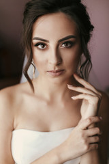 Fototapeta premium gorgeous bride putting on luxury earrings. beautiful woman portrait of getting ready for wedding. sensual moment. sexy girl posing. wedding jewelry accessories