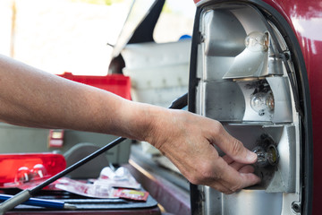 Obraz premium Replacing a burned out stop light on a vehicle