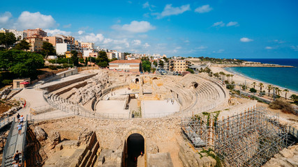 Panoramic view of the ancient roman amphitheater of Tarragona, Spain, next to the Mediterranean sea - UNESCO World Heritage Site - obrazy, fototapety, plakaty