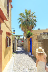 Naklejka premium Blonde walking in historic streets of old town Rhodes, Dodecanese, Greece