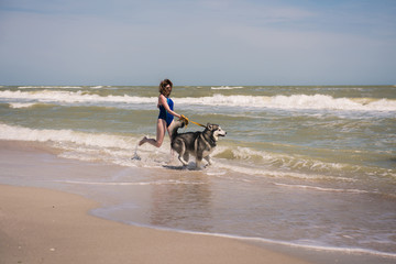 Woman run with dog at seaside