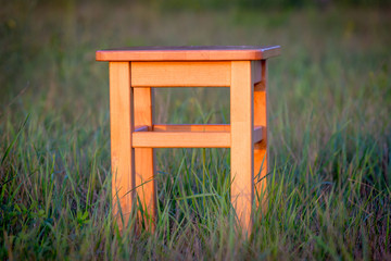 wooden stool on green meadow