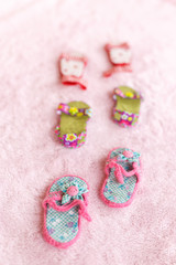 Fototapeta na wymiar Three pairs of baby sandals against a pink background.