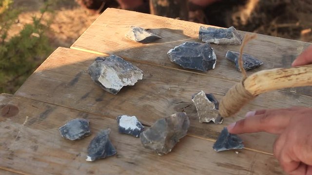 Prehistoric Man is Using Iron Tool for Sharpening Stones