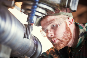 worker miller operating milling machine at industrial manufacturing factory