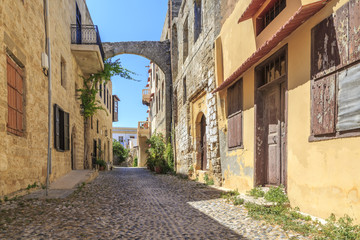 Fototapeta na wymiar Historical streets of old town Rhodes with flowers in Rhodes, Dodecanese, Greece