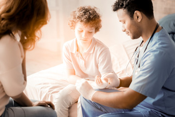 Fototapeta premium Give it to me. Profile photo of attentive doctor that bowing head and being in uniform while doing his job