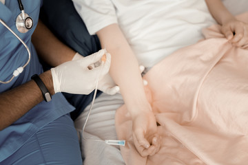 Rest cure. Competent doctor keeping stethoscope around his neck while holding dropper in left hand and going to treat his patient