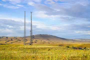 2 mobile phone base stations with cloudy sky background in the country in Turkey. Competition for mobile phone users.