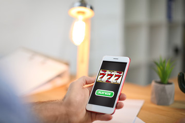 Man using cell phone indoors, closeup