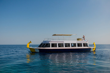 tour boat in open sea at horizon background