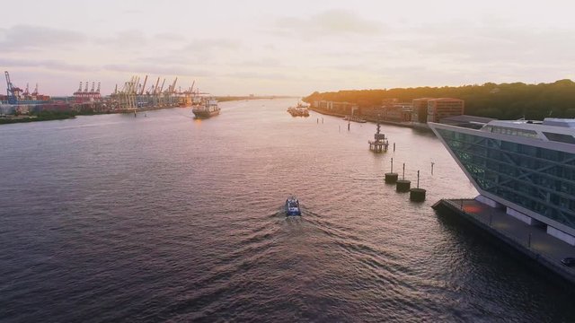 Aerial view of amazing sunset at port of Hamburg, Germany. Boats, ships and beautiful buildings. NORDAKADEMIE Graduate School building.