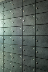 a lot of metal gray mailboxes with numbers on the doors, shot close-up