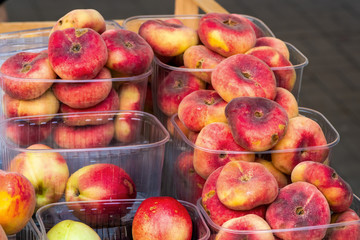 fresh peaches in plastic boxes on the table