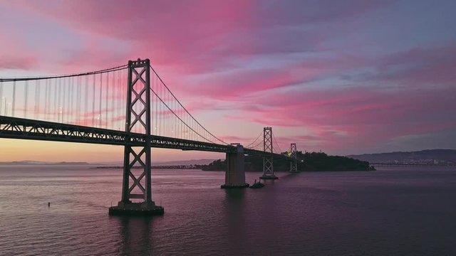 Aerial cityscape flythrough video of the Bay Bridge and San Francisco skyline with colorful sunset
