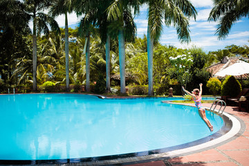 Child with goggles in swimming pool. Kids swim.