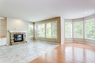 Empty living area with tons of light and fireplace.