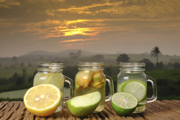 ,Lime  green apple and lemon detox water  in the morning on green nature and sunrise background