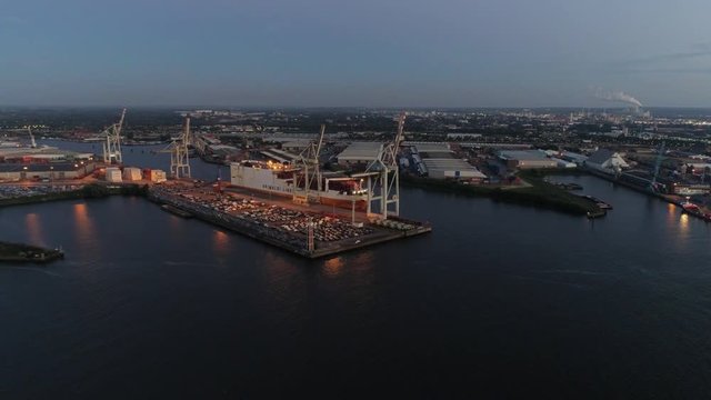 Aerial view: big cargo ship loading with containers at port of Hamburg, Germany.  Beautiful sunset at port of Hamburg.
