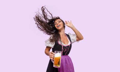 Cheerful young woman in Bavarian dress holding beer , hair flick , Oktoberfest 