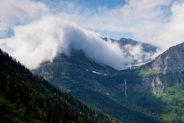 Obraz na płótnie Canvas Clouds Ooze over Logan Pass Glacier National Park