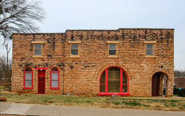Old retro brick building with arched windows with red painted woodwork under a winter sky near...