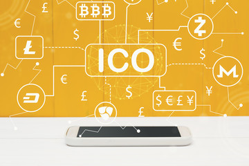 Cryptocurrency ICO theme with smartphone on yellow wooden background