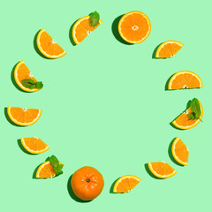 Fresh orange circle on a pastel green background flat lay