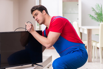 Professional repair engineer repairing broken tv