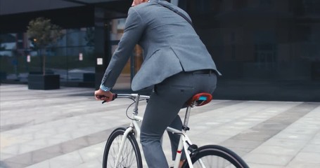 TRACKING Handsome young adult man wearing suit riding his classic bicycle to work in the morning. 4K UHD 60 FPS SLOW MOTION - Powered by Adobe