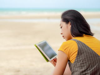 Woman use tablet while relax on the beach in summer.