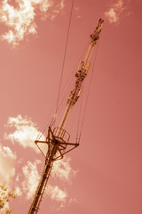 Mobile Cellular Phone System Antenna on Orange Sky and White Clouds.